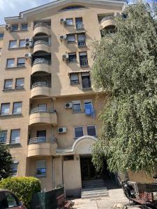 an apartment building with a tree in front of it at Comfort corner in Skopje