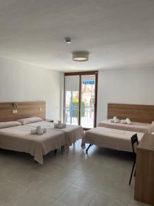 a room with two beds and a large window at Hotel Blason Junior in Peñíscola
