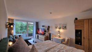 哈嫩克利博克斯维斯Böckchen - Vier Jahreszeiten的一间带床、沙发和电视的卧室