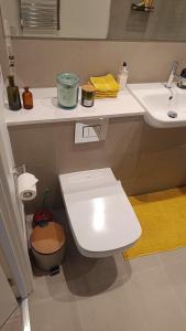 Un baño con un inodoro blanco y un lavabo. en Room in a Luxury apartment in Central London -Private toilet, en Londres