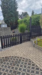a wooden fence in front of a brick walkway at De Hecksche Stuuv in Kreuztal