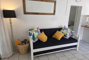 a black and white couch with pillows and a mirror at The Genet Cottage in Reebok