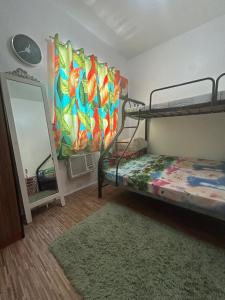 a bedroom with two bunk beds and a mirror at Norene Bianca Staycation in Carmona +7 photos