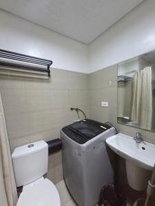 a bathroom with a toilet and a sink at Cozy Shore Hideaway in Manila