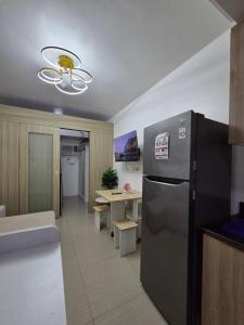 a kitchen with a stainless steel refrigerator and a table at Cozy Shore Hideaway in Manila