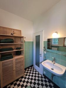 Un baño con lavabo, bañera y azulejos verdes. en Villa Lake View 2 Double Bedrooms, en Lugano