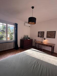 Un dormitorio con una cama y un escritorio y una ventana. en Villa Lake View 2 Double Bedrooms, en Lugano