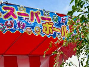 東京にあるOMATSURI BASE Nakanoshimbashiのサーカスのテントからぶら下がっているサーカスの看板