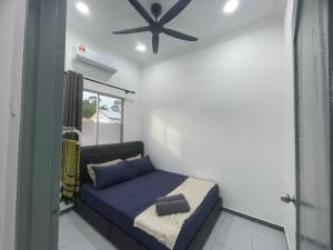 a bedroom with a bed and a ceiling fan at Casa de Alyzaa in Kampong Lendu