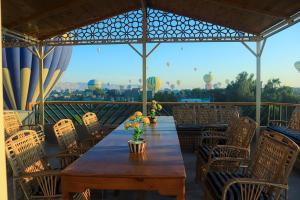 a wooden table with chairs and a view of a hot air balloon at Holiday Dream Of Luxor in Luxor