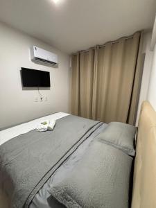 a bedroom with a bed and a flat screen tv at Flat Garden Açores Tamandaré Jardim Privativo Piscina Infinity in Tamandaré +48 photos