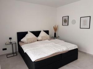 Un dormitorio con una cama grande con sábanas blancas. en Die Stadtvilla, en Holzminden