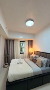 een slaapkamer met een groot bed met een lamp erop bij Suite Escapes at Brenthill Baguio nr SM and Session Rd in Baguio +25 foto's