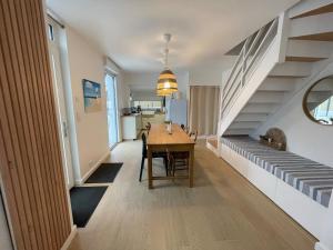 a dining room with a table and a staircase at Cocon d'Aurore in La Baule