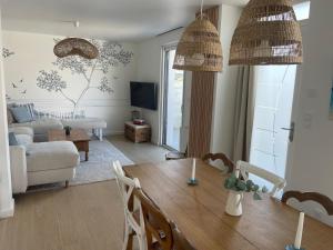 Una sala de estar con una mesa de comedor y una sala de estar con un sofá. en Cocon d'Aurore, en La Baule
