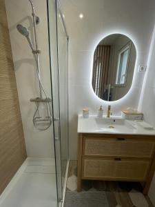 Un baño con ducha, lavabo y espejo. en Cocon d'Aurore, en La Baule