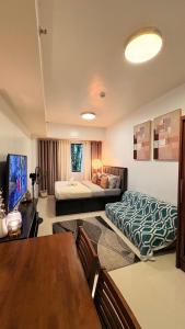 a living room with a bed and a table at Suite Escapes at Brenthill Baguio in Baguio +25 photos