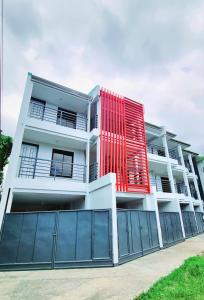 a white building with a red facade at Flat 35, Unit 1C in Manila