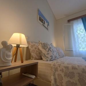 a bedroom with a bed with a lamp and a window at A home away from your home in Chios +22 photos