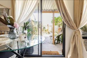 a dining room with a glass table and a large window at Garden Guesthouse in Sydney