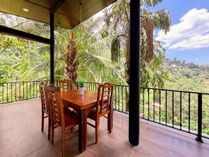 a wooden table and chairs on a balcony with a view at Rose Dale Guest Inn Ella in Ella