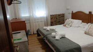 a bedroom with two beds with towels on them at Pensión Atlántico in Muxia