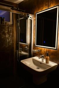 a bathroom with a white sink and two windows at Villa Perle de la Montagne in Pale +10 photos