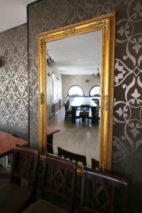 a mirror in a dining room with a table at Dworek Mitro in Gdynia