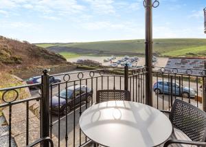 einen Balkon mit einem Tisch und Stühlen sowie Blick auf einen Parkplatz in der Unterkunft Beachcombers in Newquay Bay Resort