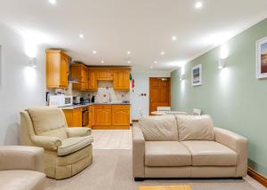 ein Wohnzimmer mit zwei Stühlen und eine Küche in der Unterkunft Beachcombers in Newquay Bay Resort + 18 Fotos