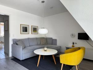 a living room with a couch and a table at Achtern Diek Haus 11 Wohnung 7 "Am Meer" in Müggenburg