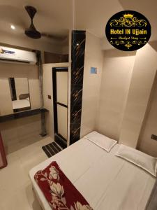 ein Schlafzimmer mit einem Bett, einem Spiegel und einem Schild in der Unterkunft HOTEL IN UJJAIn in Ujjain + 2 Fotos