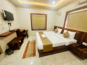 a bedroom with a bed and a desk and a television at Hotel Pramod Park in Nūāhatā