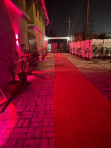 a red carpeted walkway with pink lights on a building at Hotel Pramod Park in Nūāhatā