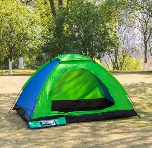 a green and blue tent sitting in a field at CAMPING NEAR AKAGERA NATIONAL PARk in Kayonza