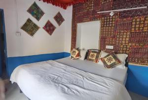 a bedroom with a bed with pillows on it at Mirvana Guest House & Camel safari in Jaisalmer
