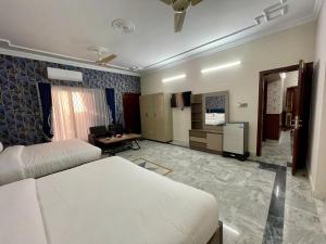 a bedroom with a bed and a living room at Landmark Guest House in Islamabad