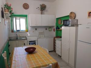 a kitchen with white cabinets and a table with a bowl on it at Casa Piera con vista mare da 2 a 4 persone in Badesi