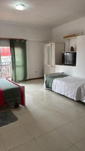 ein Schlafzimmer mit einem großen Bett und einem großen Fenster in der Unterkunft Departamento en pleno centro in San Miguel del Monte