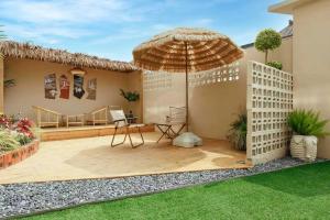 eine Terrasse mit einem Sonnenschirm und einem Stuhl darauf in der Unterkunft Xiangwang Hotel Shanghai Airport 24H Free Shuttle in Shanghai