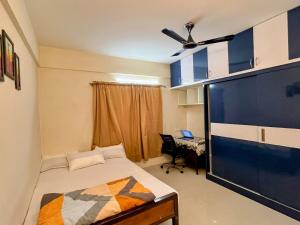 una camera con un letto e una grande TV a schermo piatto di EasyLife 2BHK Whitefield Retreat a Bangalore