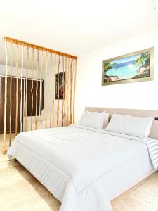 a white bed in a white room with a large bed at NEW Luxury Modern Condo by Menesse in Playa del Carmen