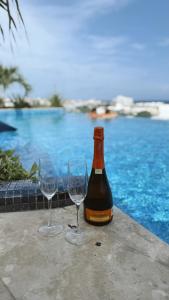 a bottle of wine and two wine glasses on a table at NEW Luxury Modern Condo by Menesse in Playa del Carmen