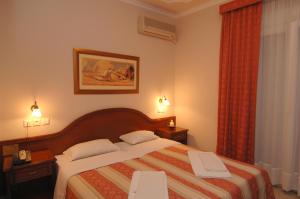 a bedroom with a bed with two chairs and a window at Kalipso in Paralia Katerinis