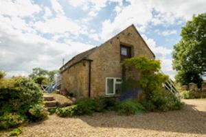 a small brick building with a window on it at Foxhill in Barton