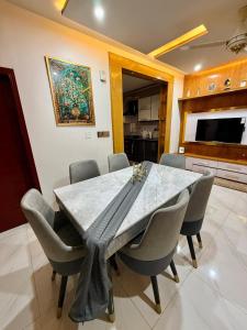 a dining room with a marble table and chairs at Bahria Town Karachi Full Furnished Guests Houses in Karachi
