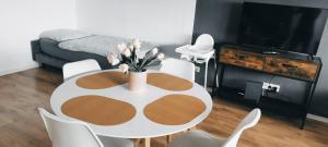 a room with a table with a vase of flowers on it at Schöne sonnige Wohnung in Jüchen
