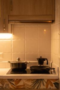 a pan on a stove with a tea kettle on it at Hostel Banana Surf House in Los Cristianos