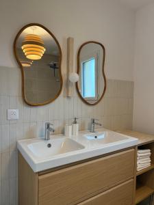 a bathroom with a sink and a mirror at Le Logis du Chêne - Piscine, proche Futuroscope in Vendeuvre-du-Poitou +15 photos