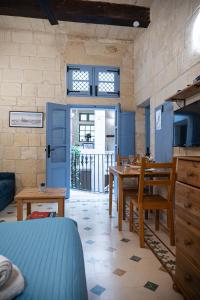 cocina con puerta azul, mesa y sillas en Casa San Carlo, en La Valeta